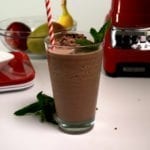 Tall glass with Chocolate Mint Slushy accented with mint leaves and a red and white striped straw.