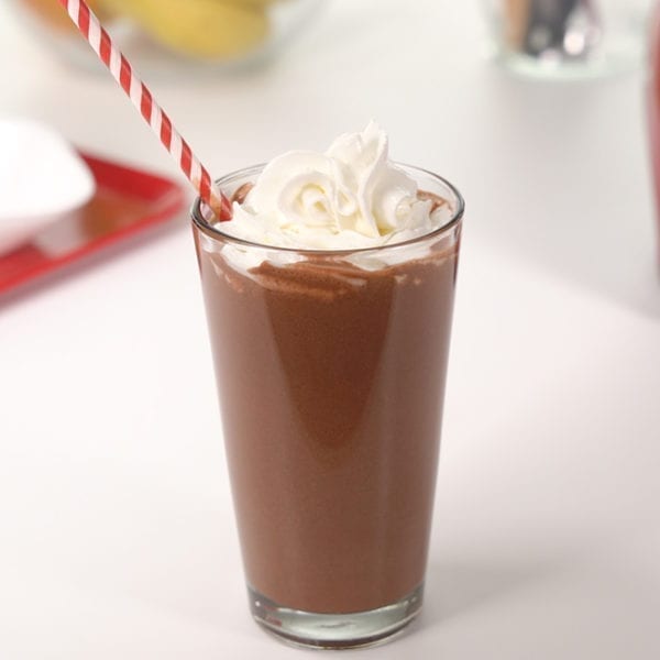 Chocolate Covered Cherry Smoothie in a tall glass with whipped cream.