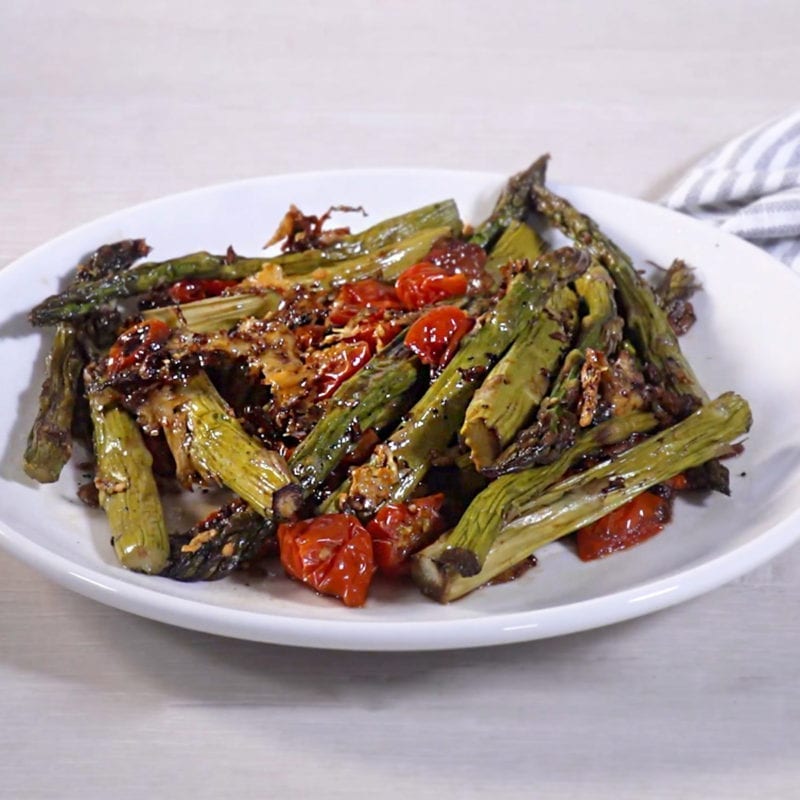 Parmesan Roasted Asparagus and Tomatoes on a white plate.