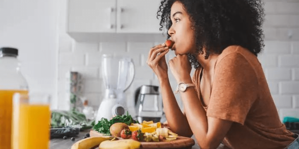 woman snacking on protein in the kitchen